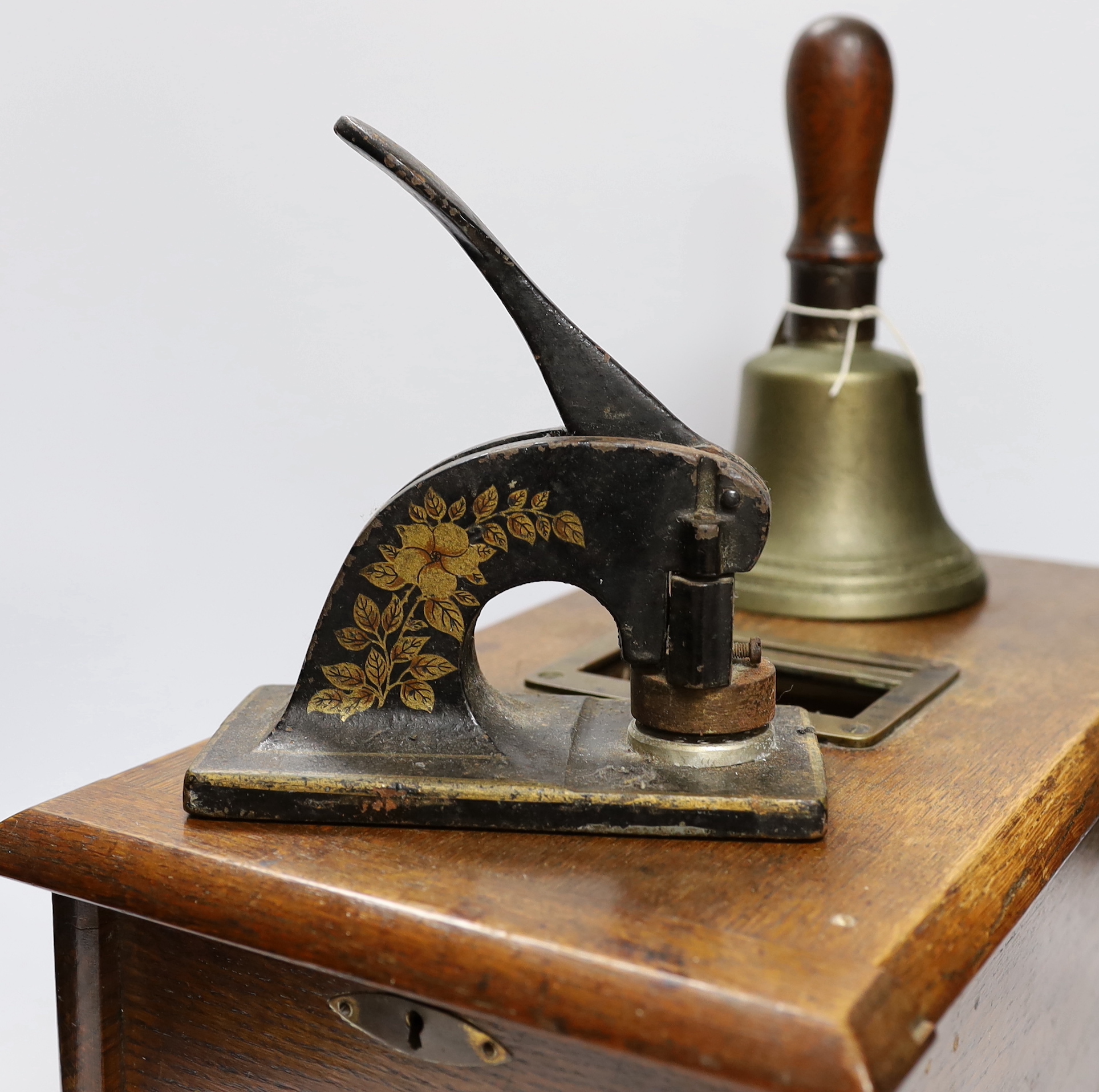 A Victorian oak Till and Company paper stamp from Alex Rice Ltd, formerly Fisher St., Lewes, and a Victorian handbell, largest 46cm wide (3)